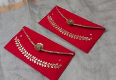 two red clutch purses with gold embellishments