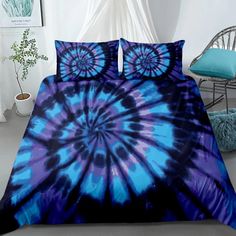 a bed with blue and black tie - dyed comforter set on top of it