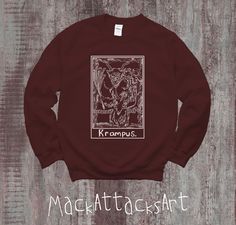 Not everyone is nice during the Christmas season. This Krampus Tarot Card Christmas Sweater is the perfect gift to segue into the Christmas Season from the Spooky Vibes of Halloween. This warm cozy sweater features a graphic of Krampus himself with a witchy/witchcraft tarot card design. Grab yours today before the holiday season! ** ABOUT ** * 50% cotton, 50% polyester * Pre-shrunk * Classic fit * 1x1 athletic rib knit collar with spandex * Air-jet spun yarn with a soft feel and reduced pilling * Double-needle stitched collar, shoulders, armholes, cuffs, and hem This product is made especially for you as soon as you place an order, which is why it takes us a bit longer to deliver it to you. Making products on demand instead of in bulk helps reduce overproduction, so thank you for making th Christmas Tarot, Witchcraft Tarot, Krampus Christmas, Crewneck Aesthetic, Tarot Card Design, Aesthetic Sweatshirt, Trendy Crewneck, Spooky Vibes, Card Christmas