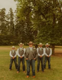 a group of men standing next to each other on top of a lush green field