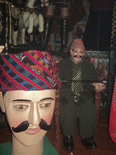 a mannequin wearing a hat and tie with fake moustaches on it