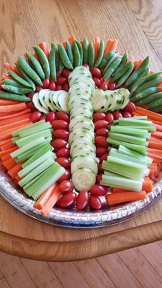 a platter filled with sliced up veggies and carrots in the shape of a cross