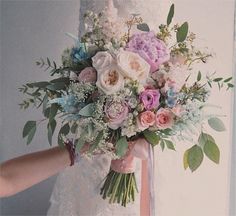 a bride holding a bouquet of flowers in her hands