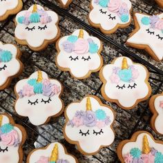 decorated cookies with pastel colors and unicorns are on cooling racks in a bakery