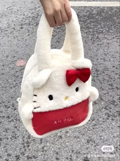 someone is holding a hello kitty purse on the street