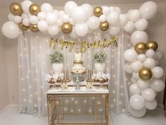 a birthday party with white and gold balloons