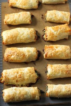 rolls are lined up on a baking sheet and ready to be baked in the oven