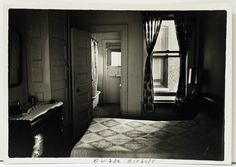 an old black and white photo of a bed in a room with curtains on the windows