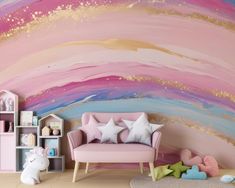 a pink couch sitting in front of a colorful wall