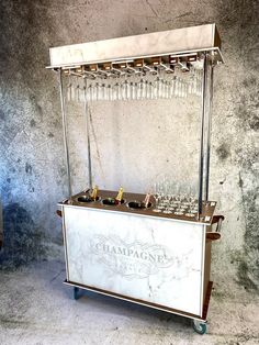 an old fashioned ice cream cart with wine glasses on it