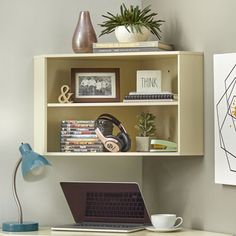 a laptop computer sitting on top of a wooden desk next to a book shelf filled with books