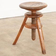 a wooden stool sitting on top of a tile floor next to a white wall and door