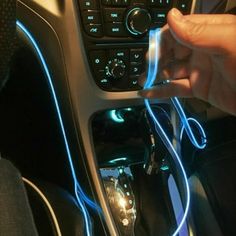 a person is plugging wires into the car's dash board and steering wheel