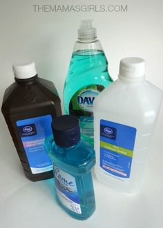 three bottles of mouthwash sitting next to each other on a white counter top,