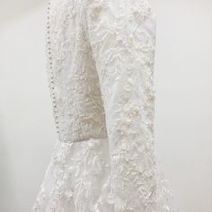 the back of a white dress with beading on it