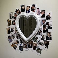 a heart shaped mirror surrounded by many photos