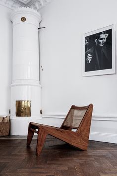 a chair sitting in the middle of a room next to a fire place