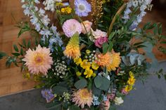 a vase filled with lots of different colored flowers