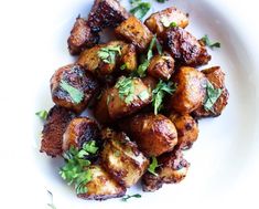 a white plate topped with fried potatoes and parsley