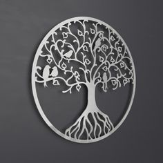 a metal wall hanging with a tree on it's face and roots in the shape of a circle