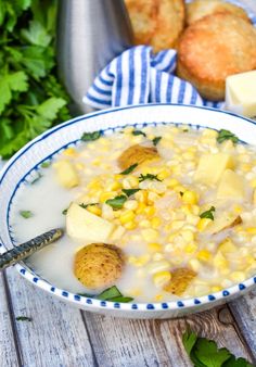 a bowl filled with corn and potatoes next to bread