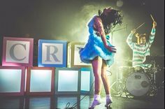 a woman in a blue dress standing on stage