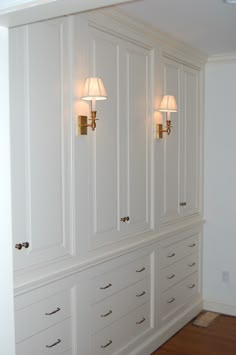 an empty room with white cabinets and lamps