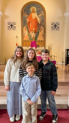 a group of children standing in front of a church alter