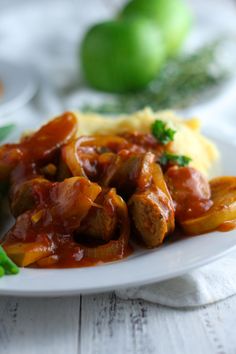 a white plate topped with meat covered in sauce