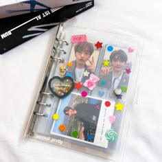 an open book with pictures and magnets attached to it next to a binder