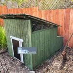 a dog house in the back yard with a sign on it's door that says,