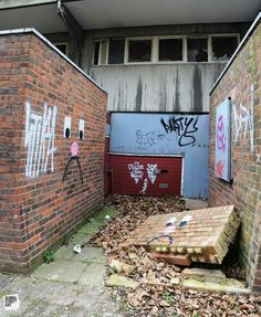 an alleyway with graffiti on the walls and wooden steps leading up to another building