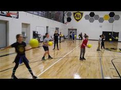 children playing with yellow balls in an indoor gym