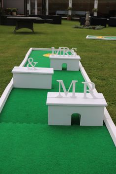 several white benches sitting on top of a green field