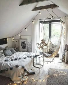 a bedroom with a hammock hanging from the ceiling and pillows on the bed