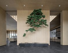 a tree is hanging from the wall in a room with black marble floors and walls