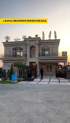 a man standing in front of a house with the words kaval brown house for sale