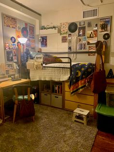 a dorm room with a bed, desk and other items on the floor in it