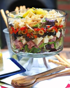 a glass bowl filled with lots of different types of food on top of a table