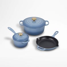 three blue pots and pans on a white background