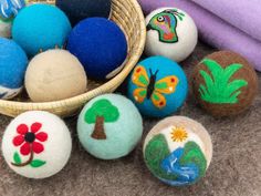 a basket filled with different colored balls on top of a floor next to a blanket