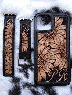 a cell phone case with sunflowers and initials on the side, sitting next to a belt