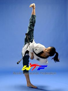 a woman doing a handstand in the air with her arms up and legs down