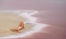 a woman laying on the beach in her bathing suit