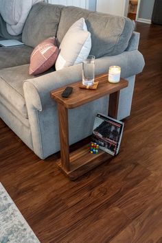 a living room with a couch, coffee table and bookshelf on the floor