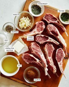 raw meat on a wooden cutting board with spices and seasonings around the steaks