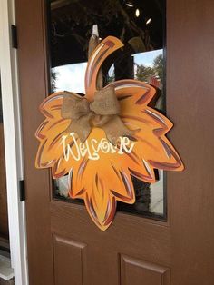 a welcome sign on the front door of a house with a burlocked bow