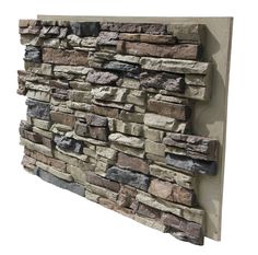 a stone wall mounted on the side of a building with grey and brown bricks in it