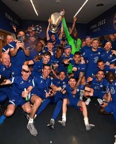 the chelsea team celebrate with the trophy