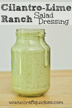 a jar filled with green liquid sitting on top of a wooden table